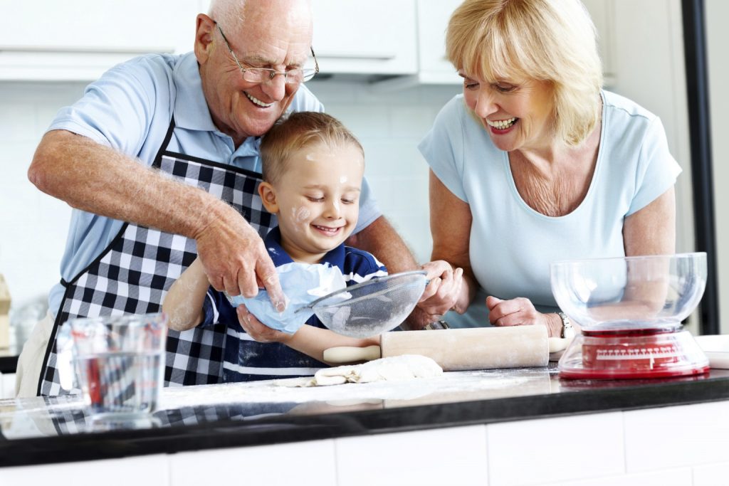 Senior couple and small kid preparing food